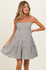 woman wearing a striped tiered sundress with spaghetti straps and a flared skirt, featuring a playful summer vibe
