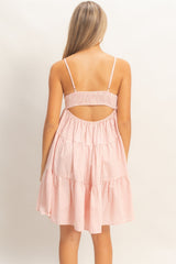 woman wearing a pink and white striped tiered sundress with a smocked back and thin straps