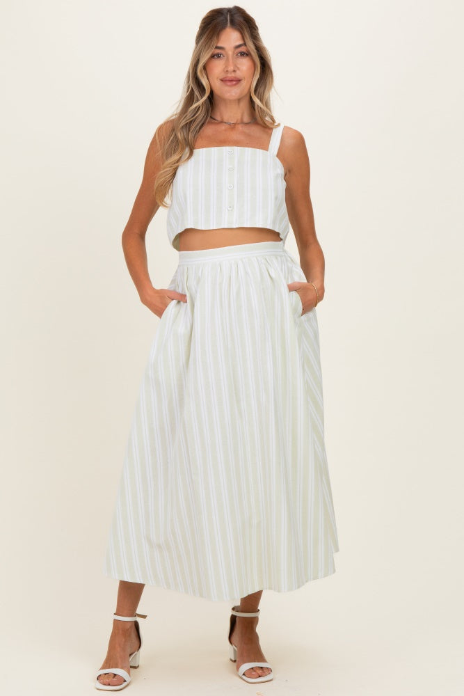 woman wearing a light green and white striped maternity crop top and matching maxi skirt with pockets