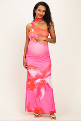 woman wearing a pink floral maternity maxi dress and holding her baby bump with one shoulder strap