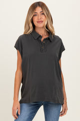 woman wearing a charcoal grey maternity polo shirt with a buttoned placket and rolled sleeves
