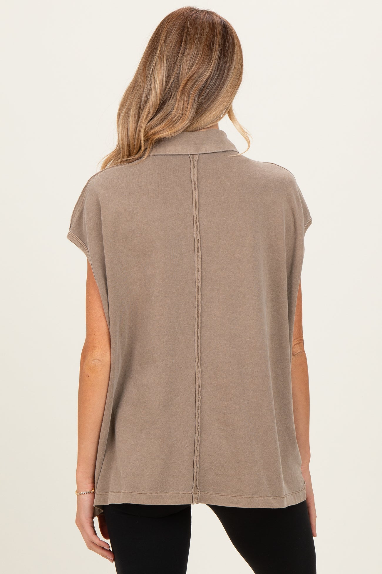woman wearing a taupe maternity top with a cowl neck and short sleeves, showing the back view