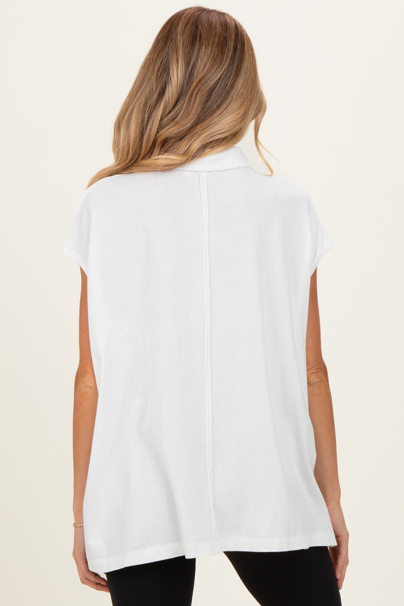 woman wearing a white short sleeve maternity top with a relaxed fit, view from the back