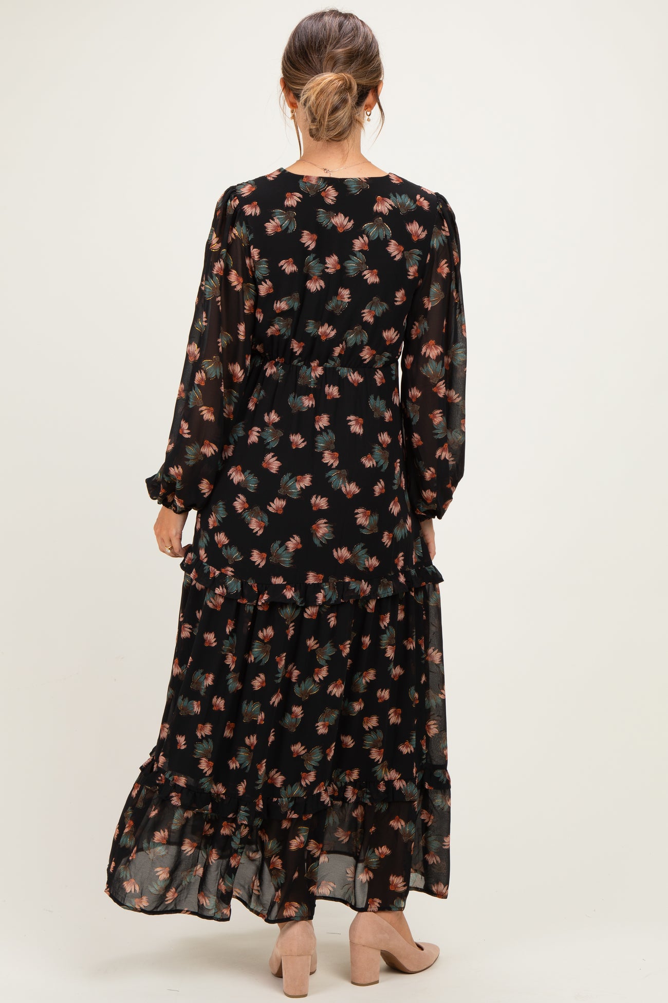 woman wearing a black floral long sleeve maternity maxi dress, seen from the back