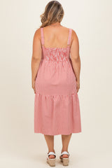 woman wearing a red and white striped maternity plus dress with a smocked bodice and tiered skirt, styled for summer