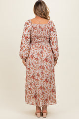 woman wearing a floral maxi maternity dress with long sleeves and a smocked back, showing off her baby bump