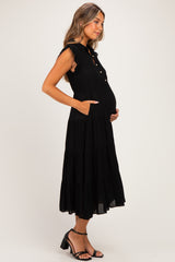 woman wearing a black sleeveless maternity dress with ruffle details and pockets, showcasing her baby bump