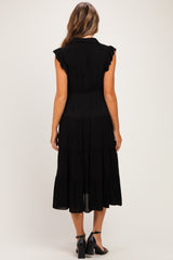 woman wearing a black maxi maternity dress with ruffled sleeves and tiered skirt, viewed from the back