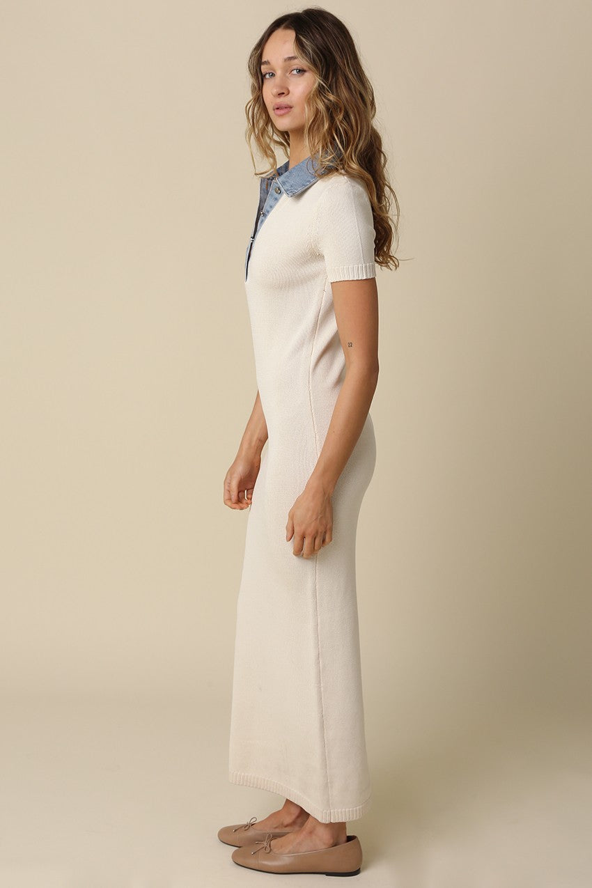 woman wearing a cream-colored knitted maxi dress with a denim collar and short sleeves, standing sideways