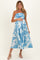woman wearing a strapless blue floral maternity dress with a visible baby bump