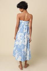 woman wearing a strapless light blue and white floral maxi dress, showing the back view