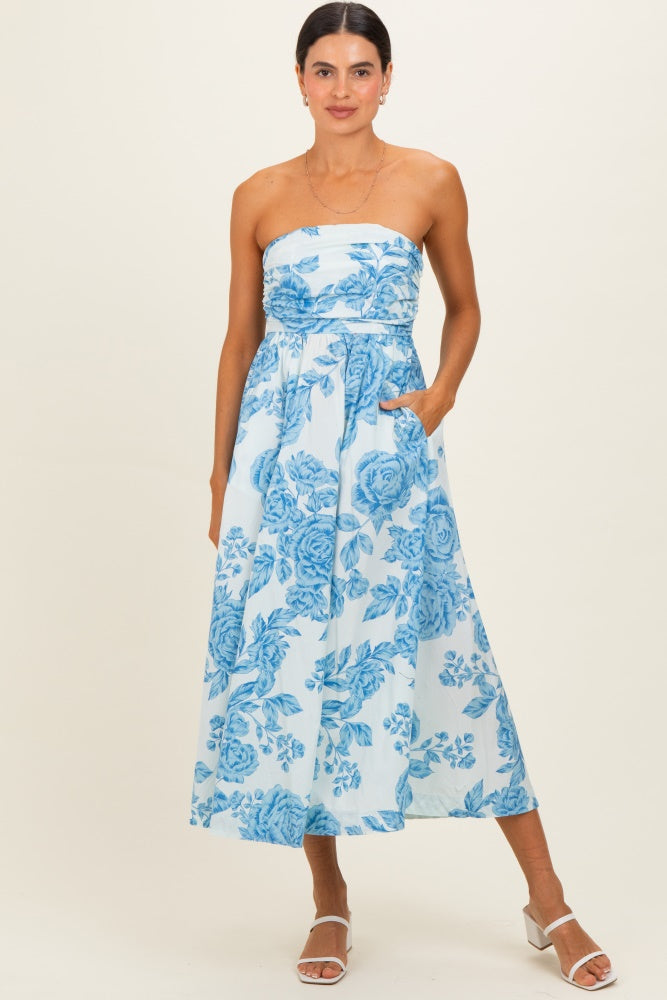 woman wearing a strapless blue floral maxi dress with pockets and a flowy skirt