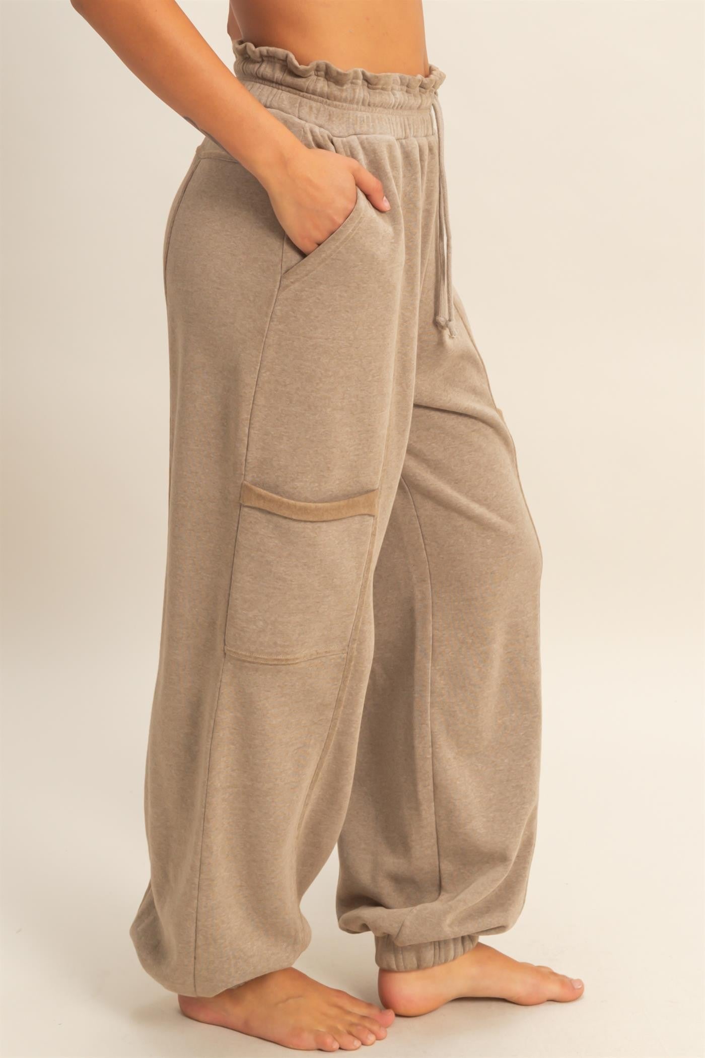 woman wearing beige high-waisted sweatpants with elastic cuffs and side pockets