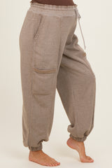 maternity wear light brown jogger pants with side pockets and elastic cuffs, model showing baby bump