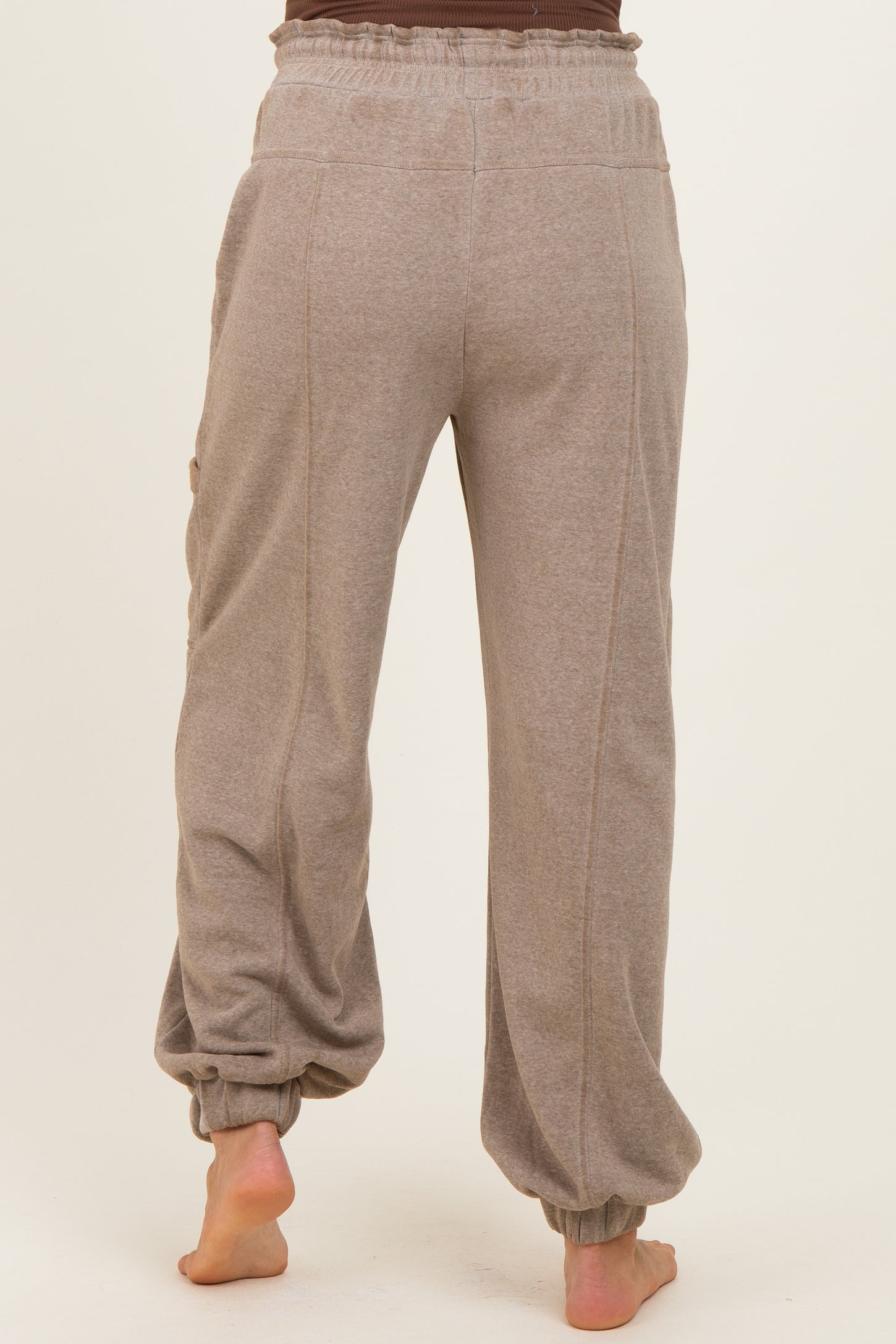 woman wearing light gray maternity sweatpants with elastic cuffs and back pockets, showing the rear view