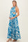 woman wearing a blue and white floral print maternity maxi dress, highlighting her baby bump while posing.