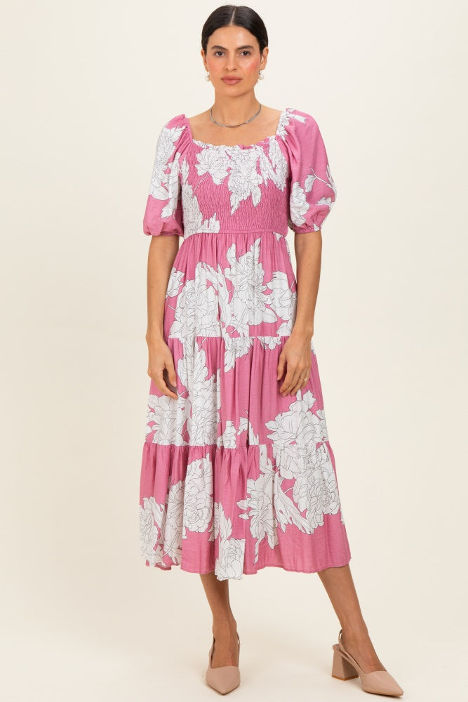woman wearing a pink floral print midi dress with puff sleeves and shirred bodice