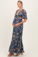 woman wearing a navy blue floral maternity maxi dress and holding her baby bump