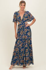woman wearing a navy floral maxi dress with short flutter sleeves and a deep v-neckline
