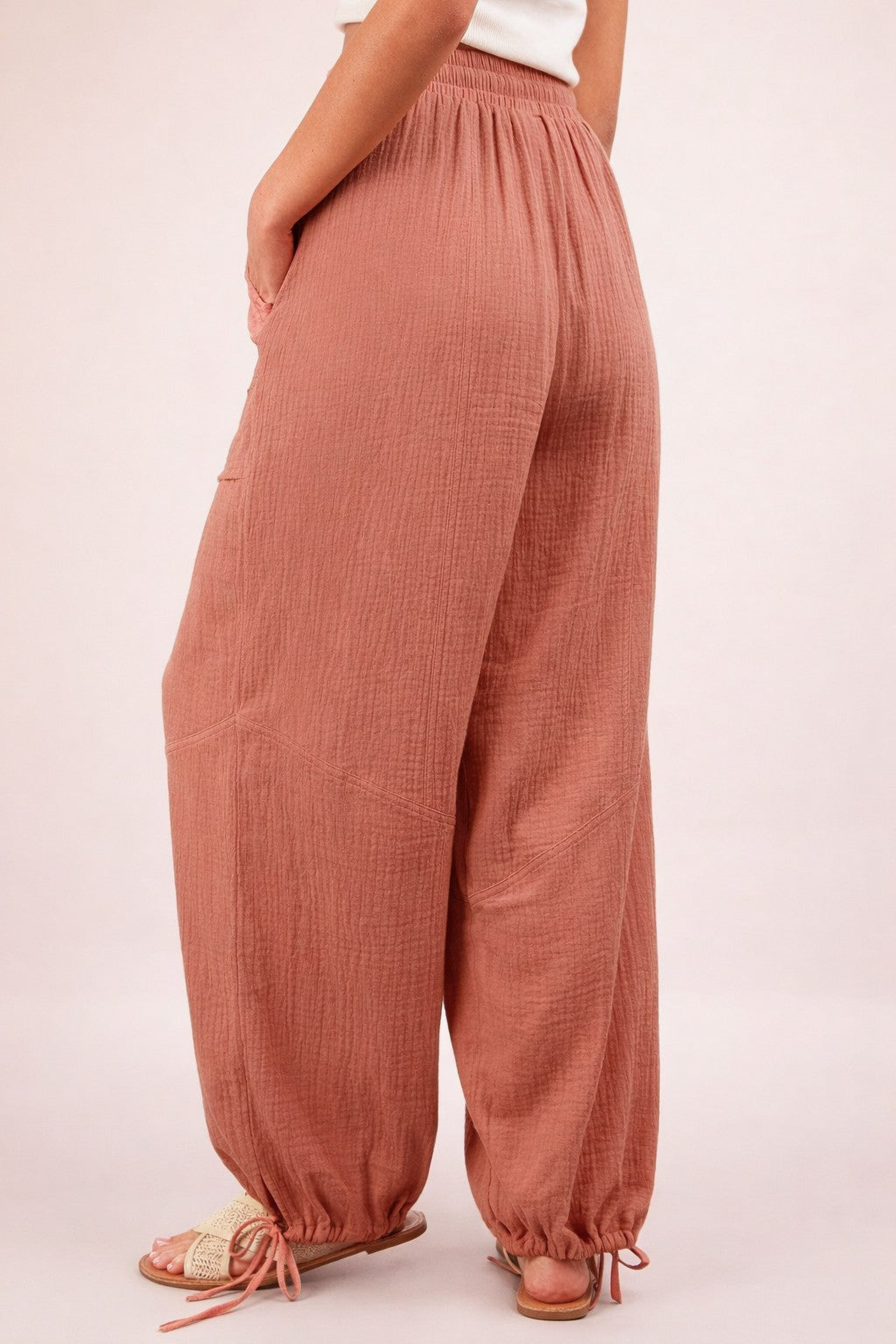 woman wearing loose-fitting dusty rose wide-leg pants with elastic waistband and gathered cuffs