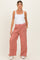woman wearing a white tank top and pink maternity wide-leg pants with pockets and a drawstring waistband
