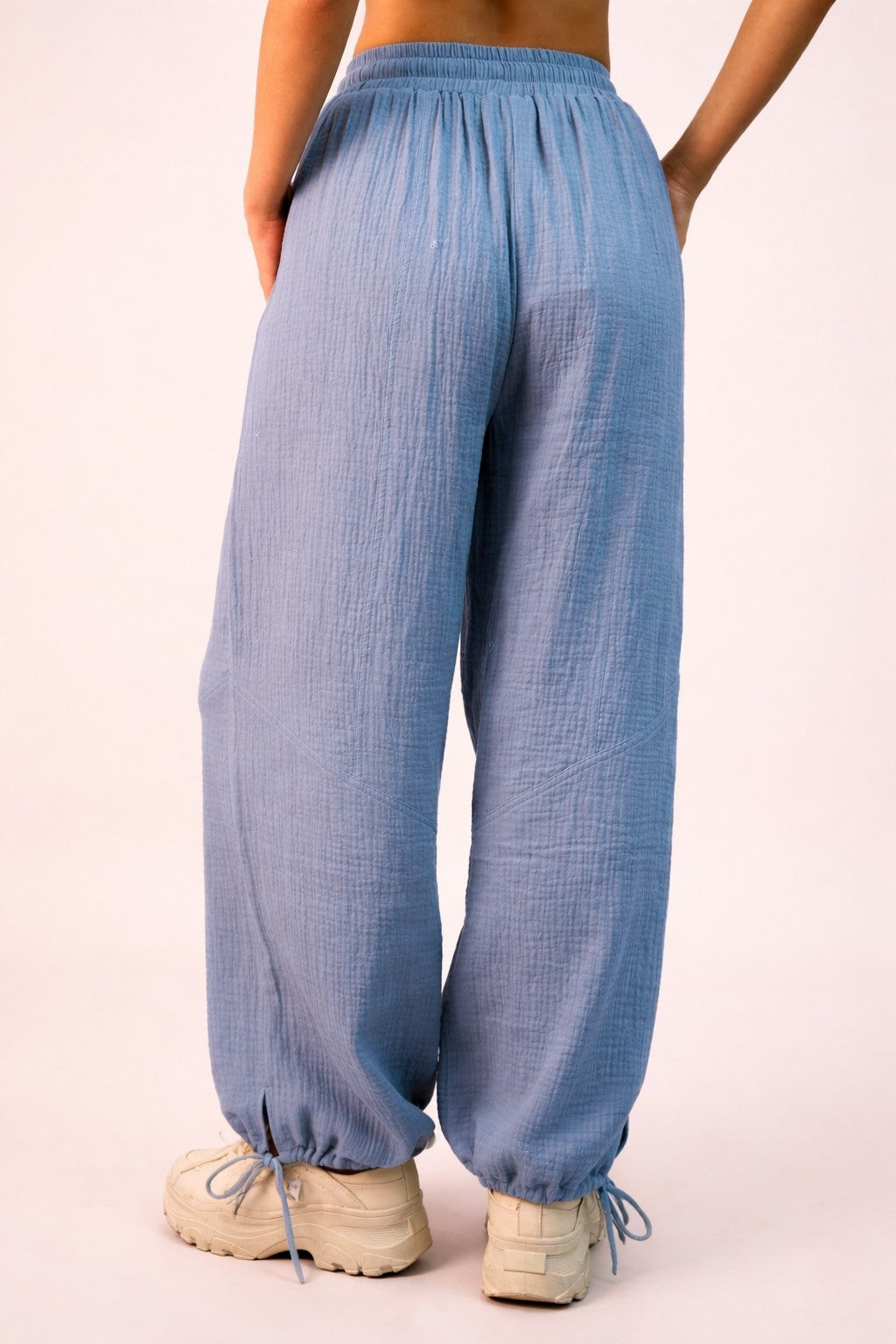 woman wearing light blue loose-fitting pants with an elastic waistband and cuffed ankles