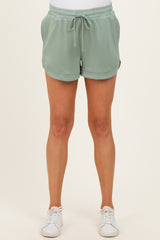 woman wearing mint green maternity shorts with a drawstring waist and side pockets