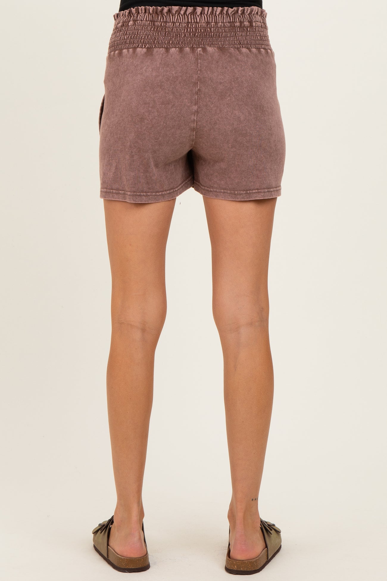woman wearing mauve maternity shorts with smocked waistband, showing the back view