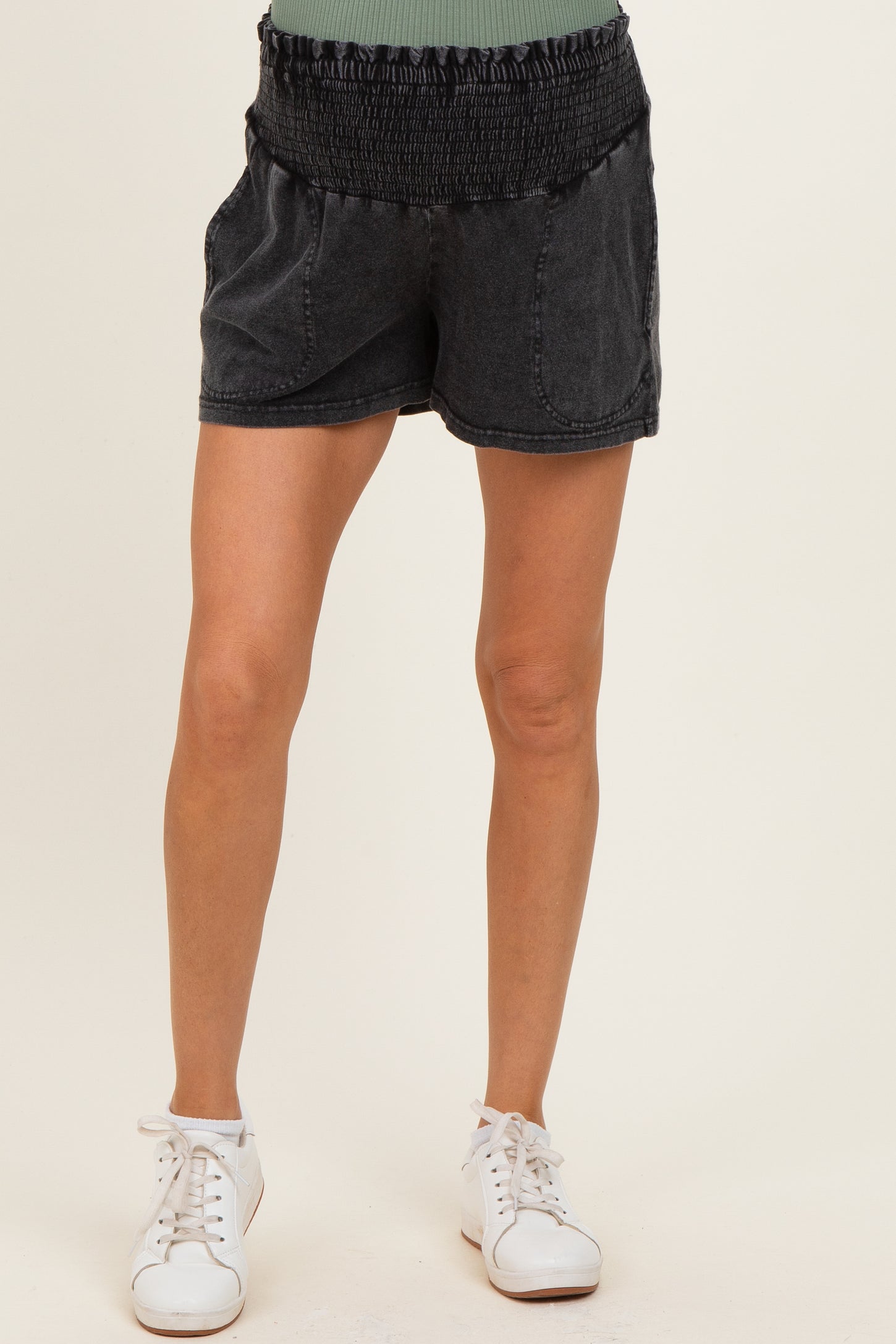 woman wearing black maternity shorts with smocked waistband and side pockets