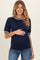 woman wearing a dark navy maternity sweater with striped collar and sleeves, holding her baby bump