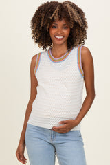 woman wearing a white sleeveless maternity top with colorful trim and holding her baby bump