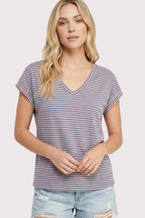 woman wearing a striped purple and white v-neck t-shirt with rolled sleeves and distressed light blue denim shorts