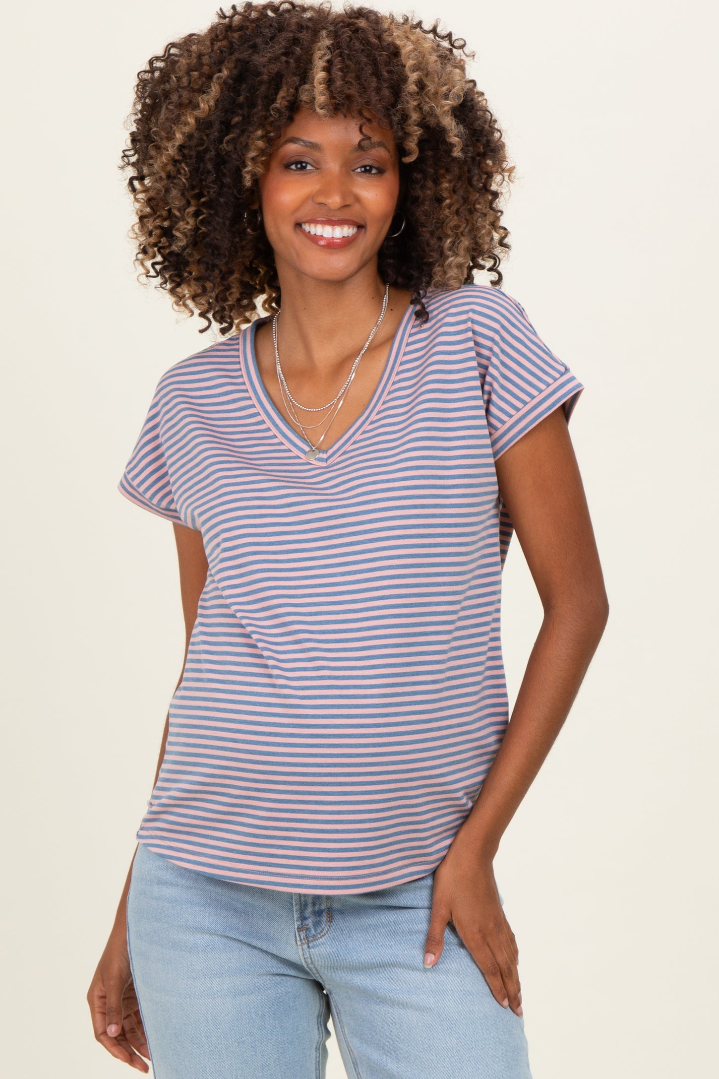 woman wearing a striped v-neck maternity top with short sleeves and a relaxed fit, showing a baby bump