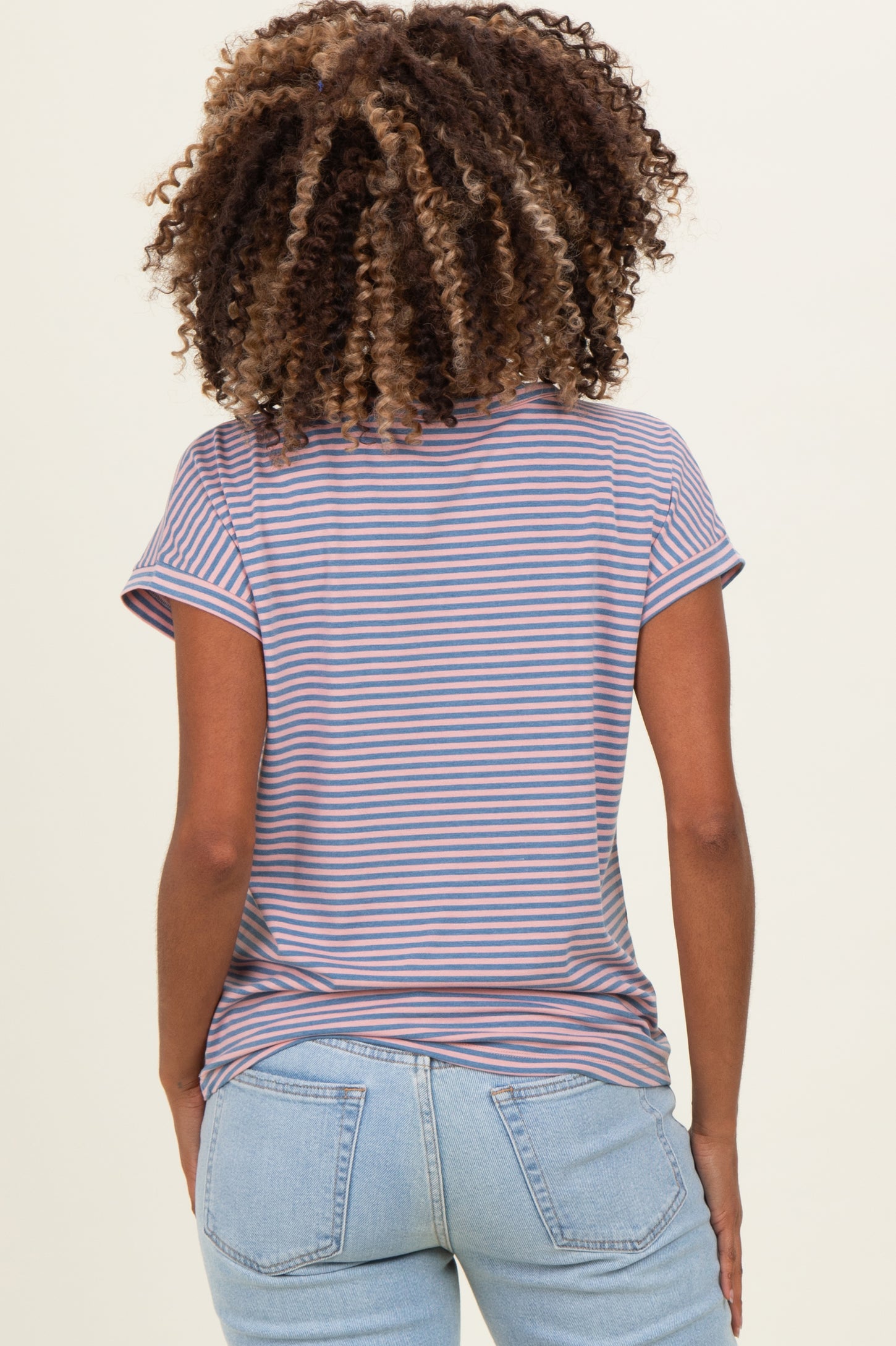 woman wearing a striped maternity t-shirt with short sleeves and blue jeans, showing her back