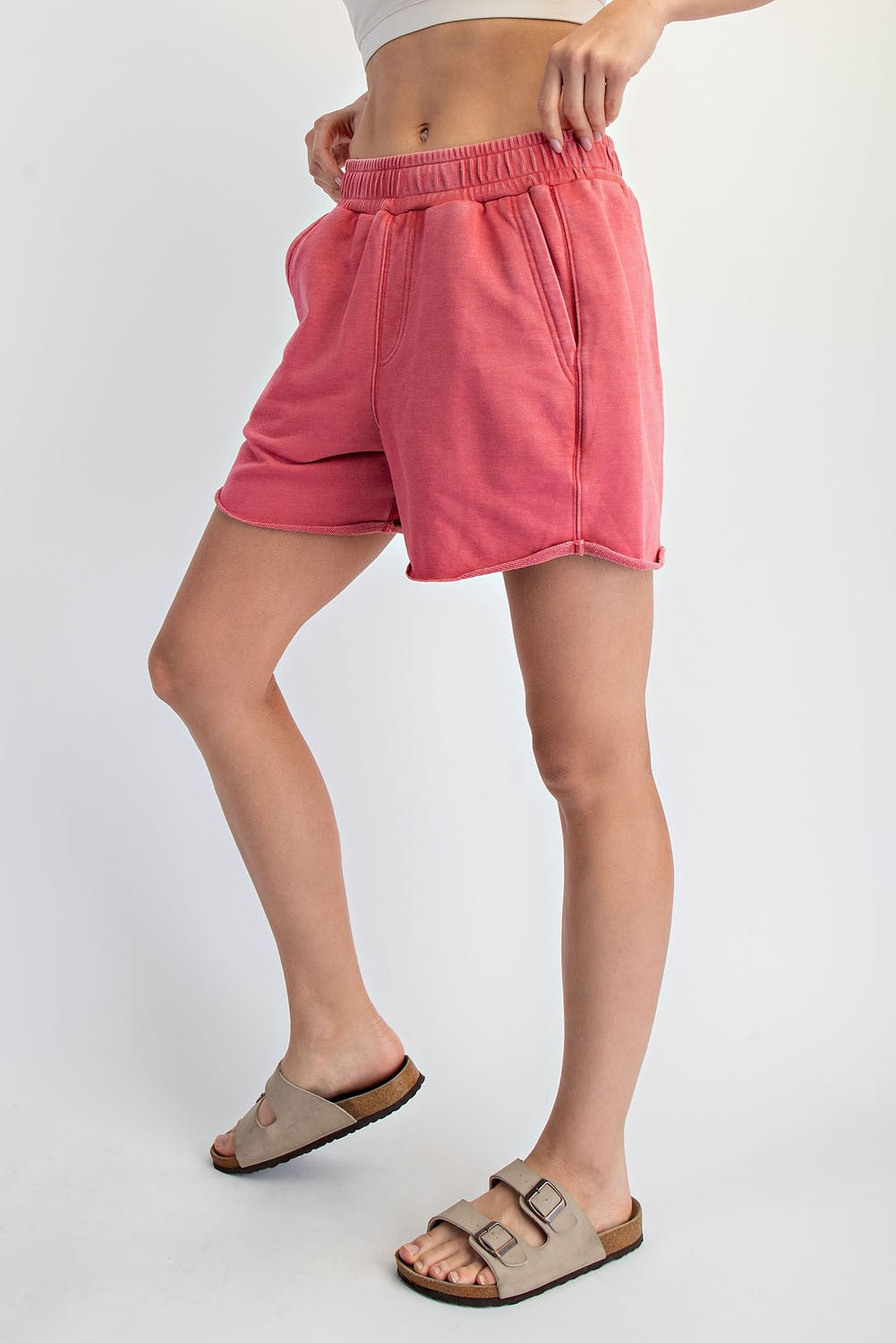 woman wearing pink elastic waistband shorts with side pockets and a relaxed fit