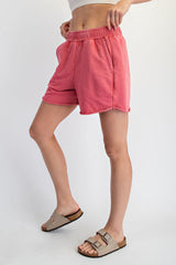woman wearing pink elastic waistband shorts with side pockets and a relaxed fit