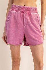 woman wearing pink tie-dye lounge shorts with an elastic waistband and frayed hem