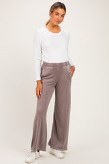 woman wearing a white long sleeve maternity top and gray wide-leg maternity pants with pockets