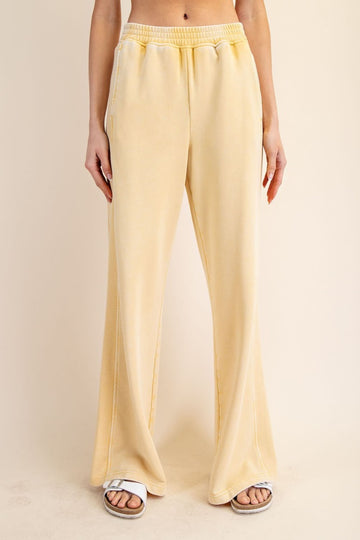 woman wearing light yellow wide-leg lounge pants with an elastic waistband and side pockets
