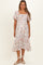 woman wearing a white floral print maternity dress with short flutter sleeves and a tie waist