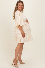 woman wearing a floral short sleeve maternity dress and holding her baby bump