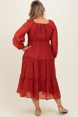 woman wearing a red tiered maxi dress with long sleeves and a smocked waist, showcasing her baby bump