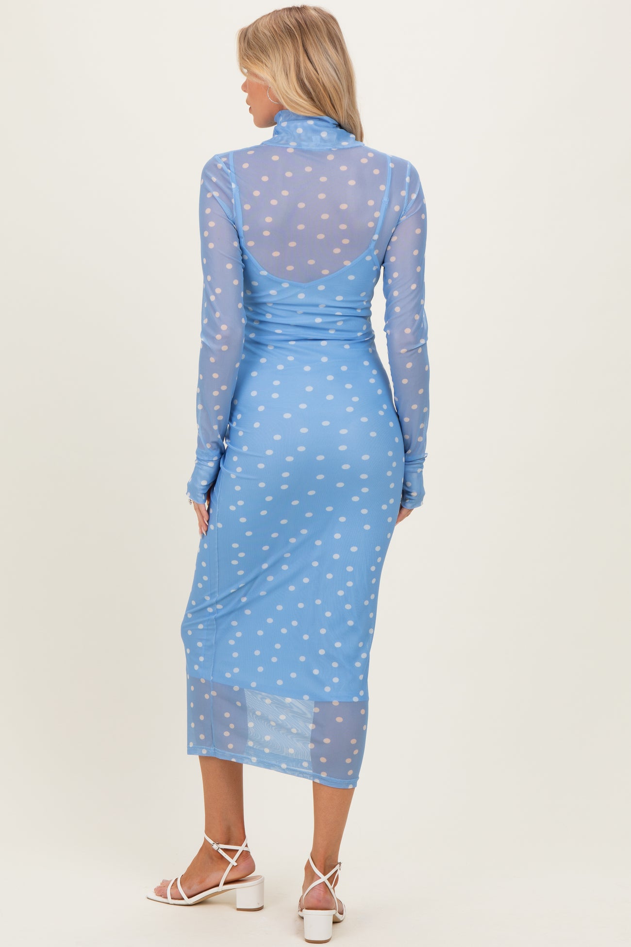 maternity wear long sleeve blue dress with white polka dots, model seen from back with a form-fitting silhouette