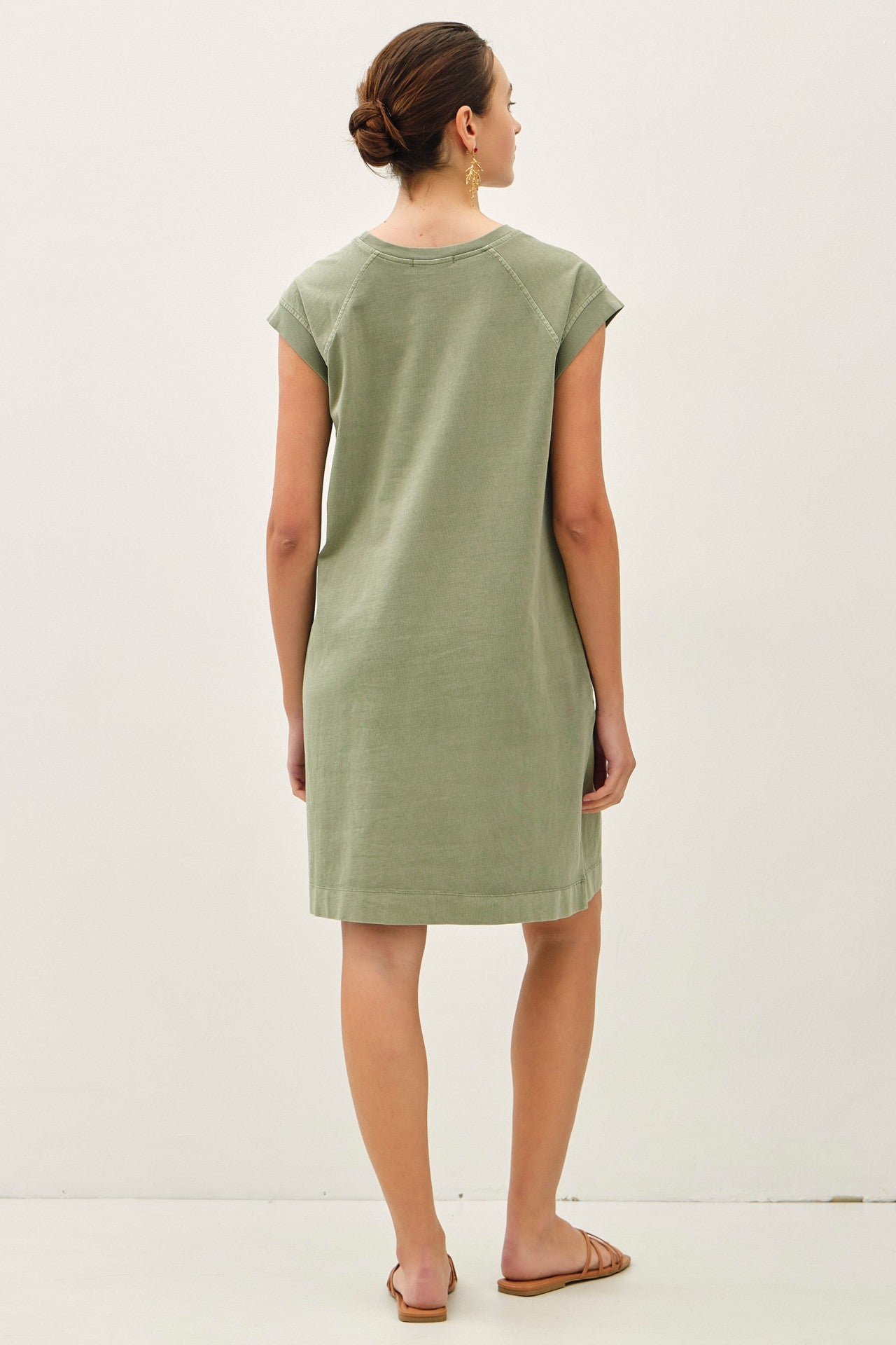 woman wearing a green short sleeve dress with a relaxed fit and back seam details