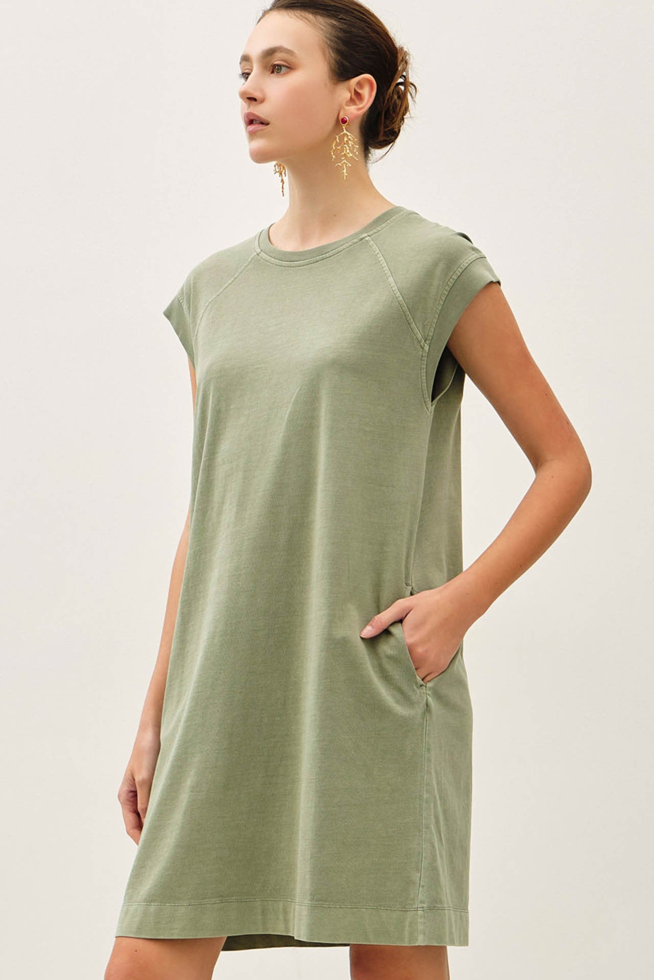 woman wearing a green short sleeve casual dress with side pockets and a relaxed fit