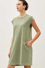 woman wearing a green short sleeve casual dress with side pockets and a relaxed fit