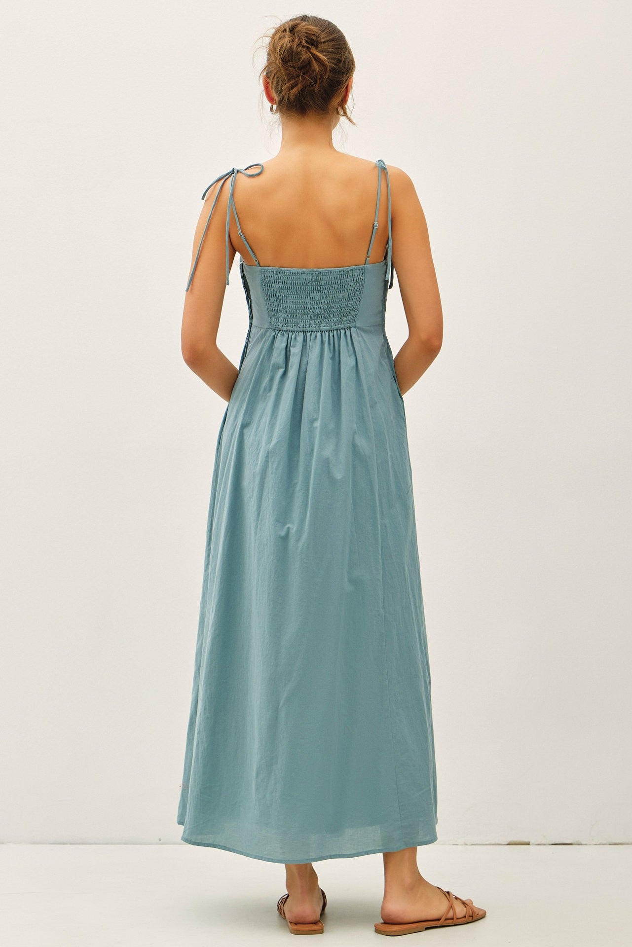 woman wearing a blue maxi dress with tie straps and smocked back detail