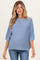 woman wearing a light blue oversized maternity sweater with half sleeves and a relaxed fit