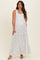 woman wearing a white floral print maternity maxi dress with square neckline and tiered skirt, showcasing her baby bump