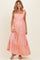 woman wearing a pink floral maternity maxi dress with tiered ruffles and a visible baby bump